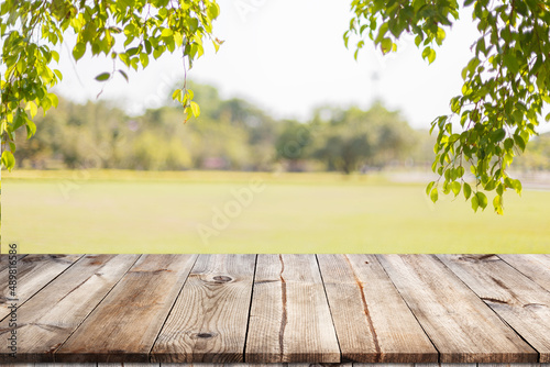 Empty wooden table with garden bokeh for a catering or food background with a country outdoor theme,Template mock up for display of product