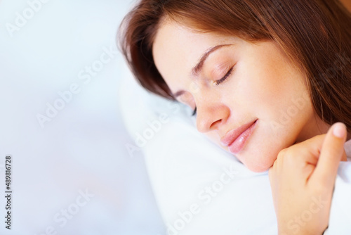 Closeup of a pretty female fast asleep in bed. Closeup portrait of a cute young female fast asleep in bed.