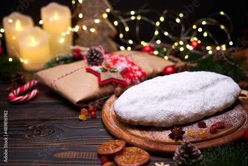 Traditional Christmas stollen cake and New Year decorations on wooden background © Anatoly Repin