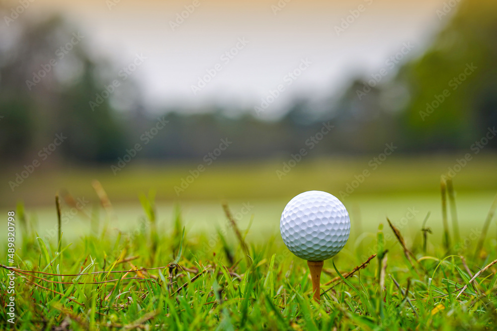 Golf ball on tee in beautiful golf course at sunset background. Golf ball on tee in beautiful golf course at sunset background.
