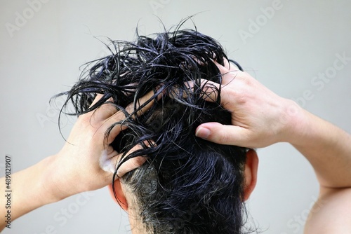 シャンプーをする人物の後ろ姿