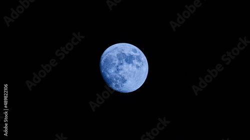 image with blue full moon on black night sky