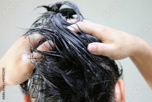 シャンプーをする人物の後ろ姿