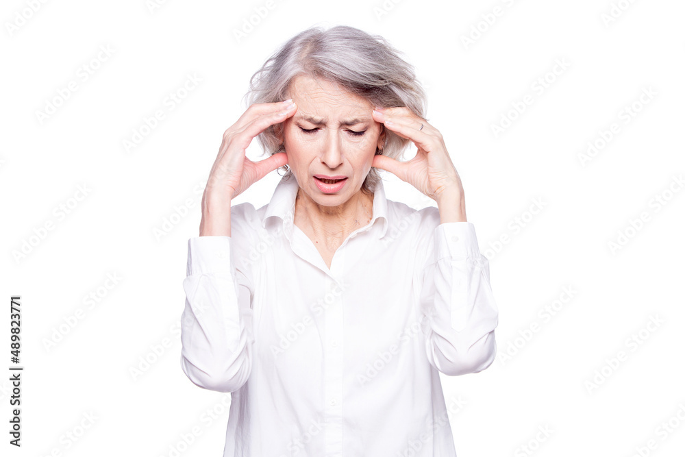 Portrait of an old but modern trendy woman suffering from a headache or migraine holding her head in her hands with a desperate expression and screaming from pain isolated on white background Portrait of an old but modern trendy woman suffering from a headache or migraine holding her head in her hands with a desperate expression and screaming from pain isolated on white background