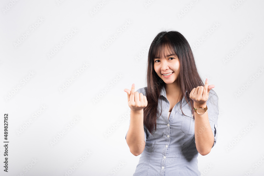 Woman standing her smile confidence showing mini heart sign with her finger isolated white background, Asian happy portrait beautiful young female send love and happy valentine in studio shot