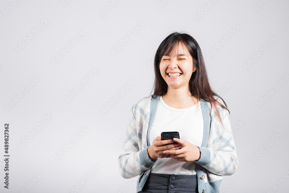 Woman excited read social network feedback on smartphone studio shot isolated white background, young female smiling typing sms message on mobile phone in social media Woman excited read social network feedback on smartphone studio shot isolated white background, young female smiling typing sms message on mobile phone in social media
