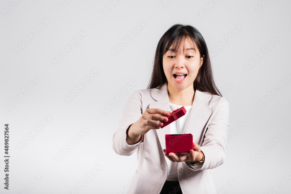 Smiling woman confidence opening a red gift box on palm isolated white background, surprise birthday or Christmas day and valentine, Asian happy portrait beautiful young female studio shot, copy space Smiling woman confidence opening a red gift box on palm isolated white background, surprise birthday or Christmas day and valentine, Asian happy portrait beautiful young female studio shot, copy space