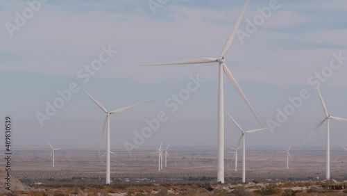 Windmills turbine rotating, wind farm or power plant, alternative green renewable energy generators, industrial field in California desert USA. Electricity generation on windfarm. El Centro, Kumeyaay. photo