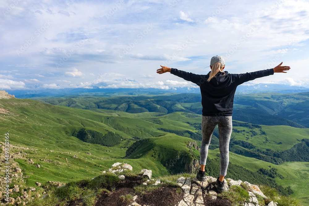 A girl on the background of the mountains and the Bermamyt plateau in Russia. June 2021 A girl on the background of the mountains and the Bermamyt plateau in Russia. June 2021