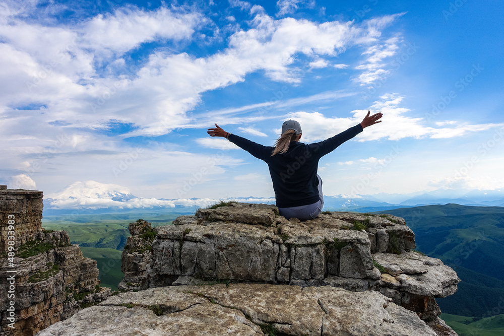 A girl on the background of the mountains and the Bermamyt plateau in Russia. June 2021 A girl on the background of the mountains and the Bermamyt plateau in Russia. June 2021