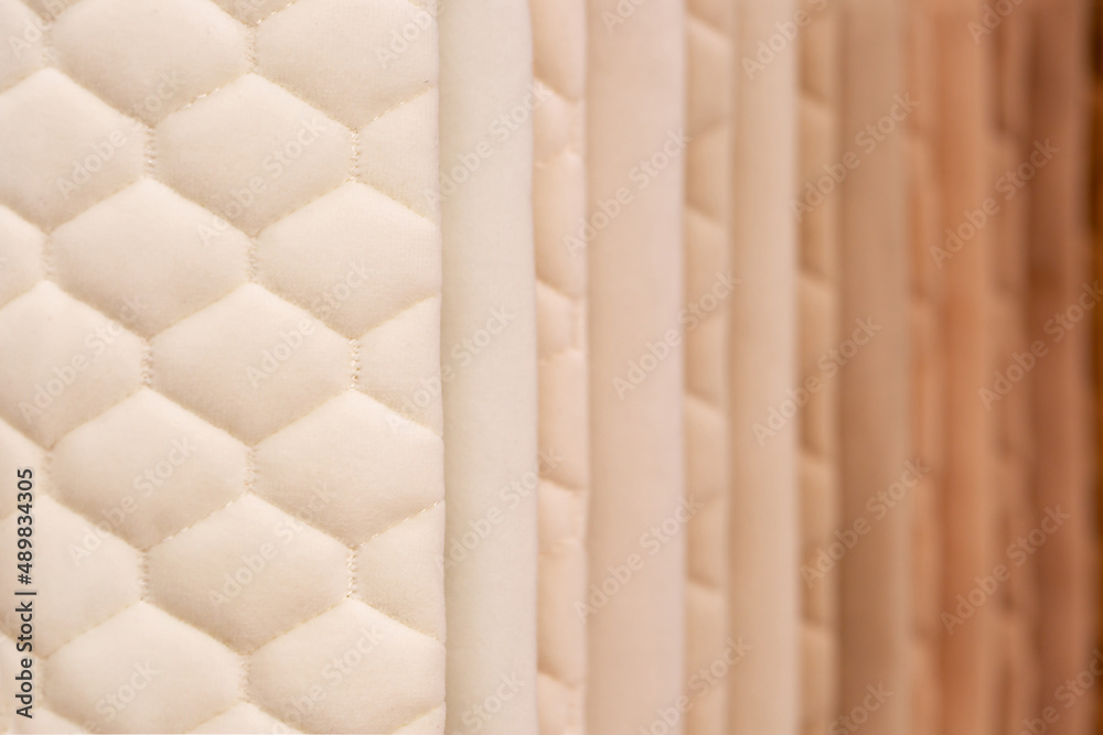 Fabric texture close up. Fabric swatches in different colors are stacked for selection. A variety of shades of upholstery material for furniture and interior. A set of multi-colored rolls of material. Fabric texture close up. Fabric swatches in different colors are stacked for selection. A variety of shades of upholstery material for furniture and interior. A set of multi-colored rolls of material.