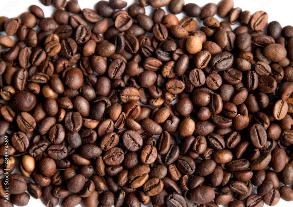 Roasted coffee beans on a white background. Coffee texture. Roasted coffee beans on a white background. Coffee texture.