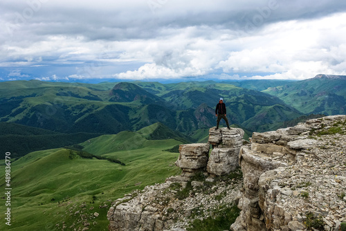 A man on the background of the mountains and the Bermamyt plateau in Russia. June 2021