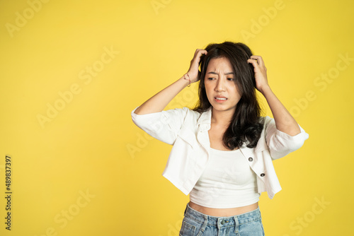 frustrated Asian young woman holding head with headache