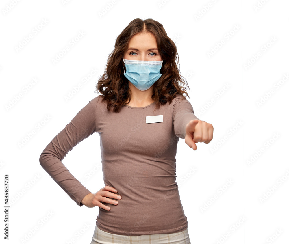 sale, shopping and pandemic concept - happy female shop assistant or saleswoman in medical mask with name tag pointing finger to camera over white background sale, shopping and pandemic concept - happy female shop assistant or saleswoman in medical mask with name tag pointing finger to camera over white background