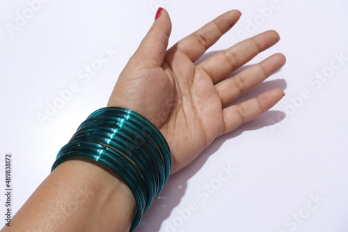 Woman's hand with many bangles on her wrist Isolated white background photo