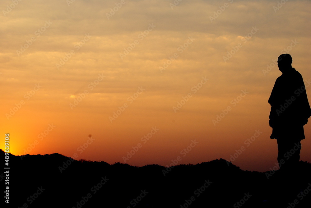 silhouette of man standing on top of mountain