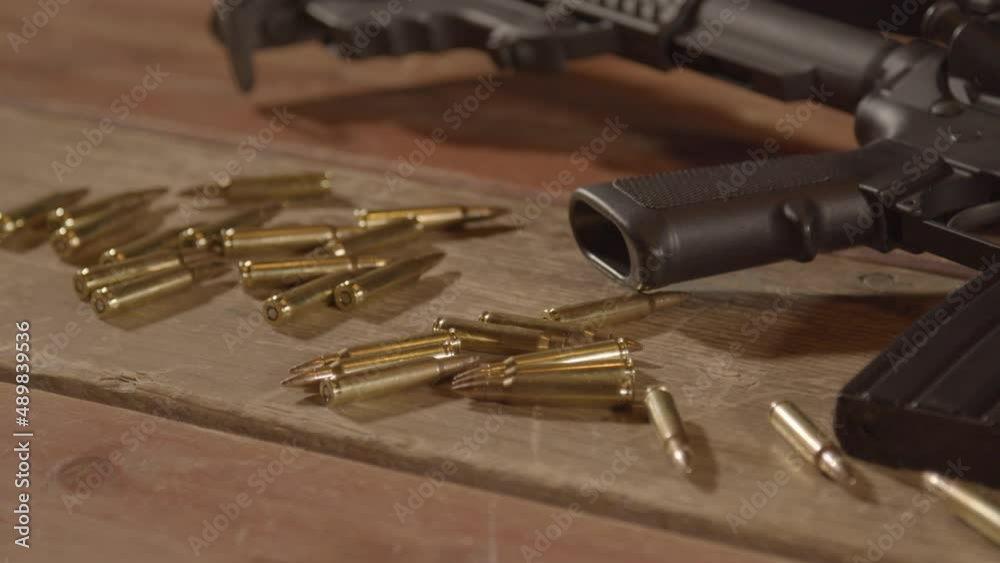 Dolly out over ammunition scattered in front of loaded AR-15 Dolly out over ammunition scattered in front of loaded AR-15