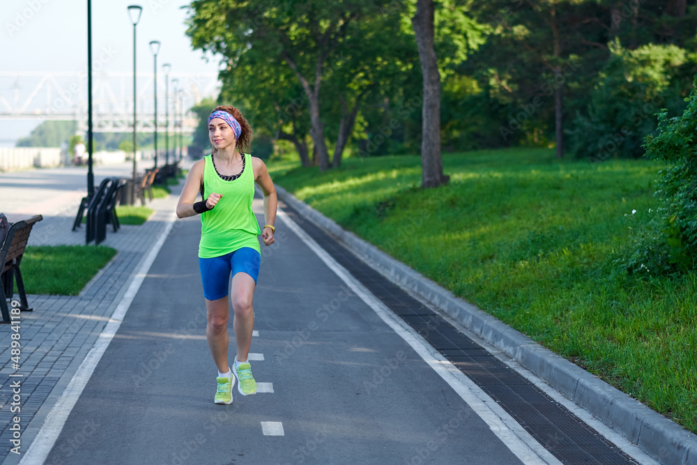 Running Woman on racetrack during training session. Female runner practicing on athletics race track