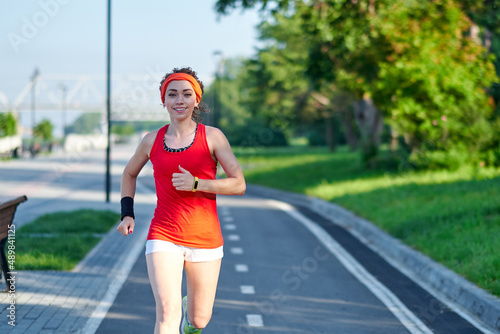 Running Woman on racetrack during training session. Female runner practicing on athletics race track