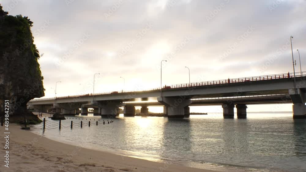 NAHA, OKINAWA, JAPAN - AUG 2021 : View of Naminoue beach (Ocean or sea) and road traffic in sunset time. Wide view, time lapse shot, dusk to night. Summer holiday, vacation and resort concept shot. NAHA, OKINAWA, JAPAN - AUG 2021 : View of Naminoue beach (Ocean or sea) and road traffic in sunset time. Wide view, time lapse shot, dusk to night. Summer holiday, vacation and resort concept shot.