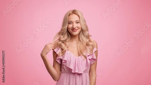 Gorgeous Lady Playing With Curled Blonde Hair Over Pink Background
