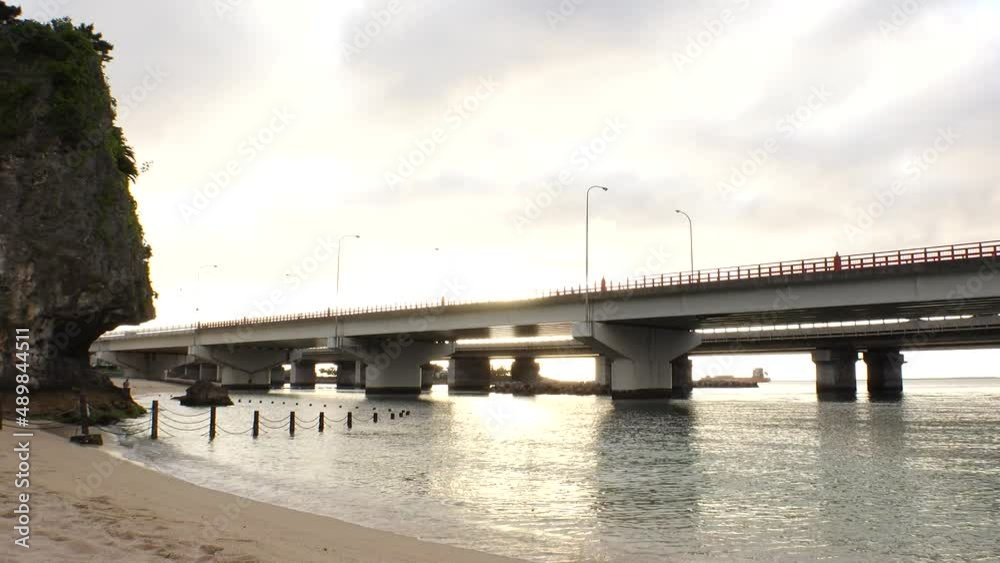 NAHA, OKINAWA, JAPAN - AUG 2021 : View of Naminoue beach (Ocean or sea) and road traffic in sunset time. Wide view, time lapse shot, dusk to night. Summer holiday, vacation and resort concept shot. NAHA, OKINAWA, JAPAN - AUG 2021 : View of Naminoue beach (Ocean or sea) and road traffic in sunset time. Wide view, time lapse shot, dusk to night. Summer holiday, vacation and resort concept shot.