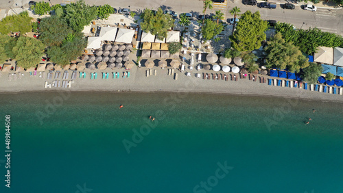 Aerial top view photo of sun beds and umbrellas in popular tropical paradise deep turquoise Mediterranean sandy crowded beach