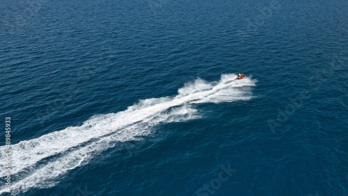 Aerial photo of jet ski with couple cruising in high speed in Caribbean tropical crystal clear deep blue waters © aerial-drone
