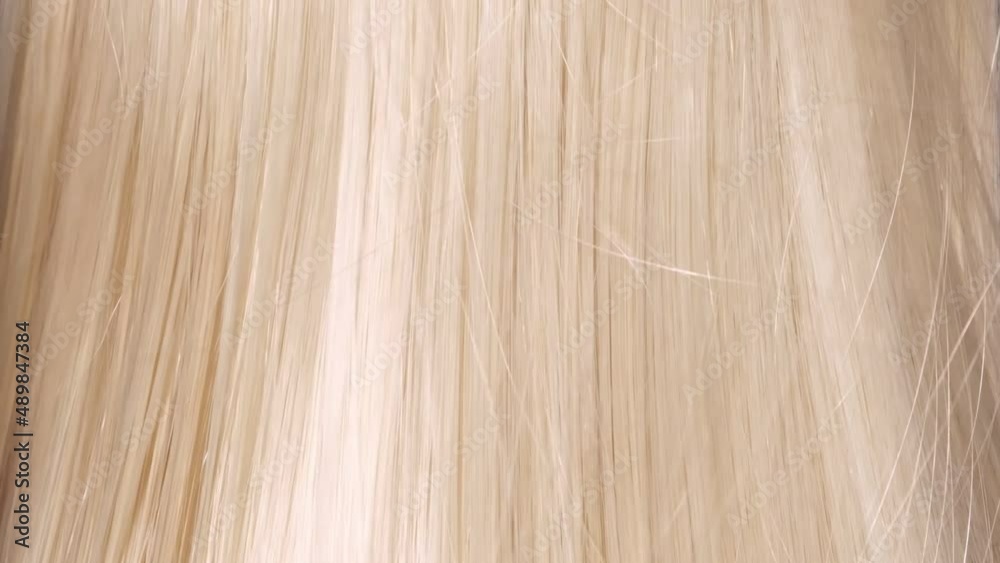 Beautiful healthy blonde Hair. A closeup view of a bunch of shiny straight blond hair in a wavy style. slow motion smooth flowing hair fluttering Beautiful healthy blonde Hair. A closeup view of a bunch of shiny straight blond hair in a wavy style. slow motion smooth flowing hair fluttering