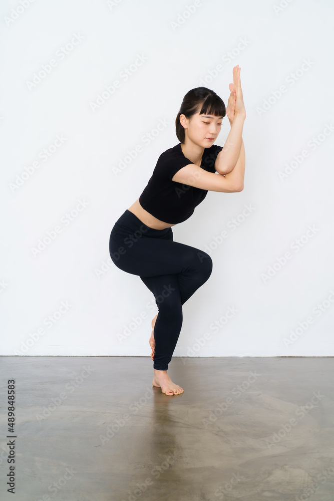 Fototapeta premium ヨガ（鷲のポーズ）をする女性