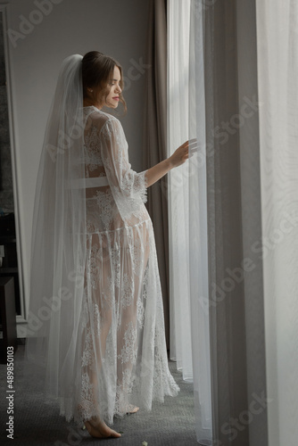 The bride in a gentle boudoir in a bright hotel room. Wedding day