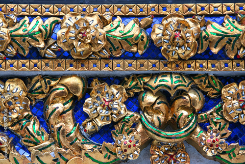 Golden Pattern at Wat Pho in Bangkok, Thailand with Floral Design of shapes and color. Vintage thai golden pattern with gems. Asian golden ornament in Thailand. Traditional decorative background © Anastasia