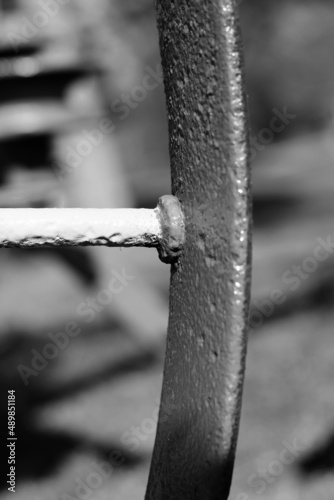 Closeup of a steel wagon wheel in a black and white monochrome.