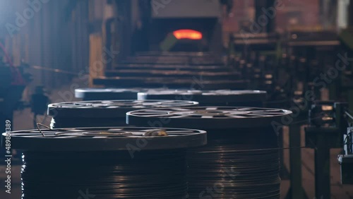 Wire is wound on bobbins in a large workshop at the factory. This is a large room where coils are lined up and metal cables are wound around them