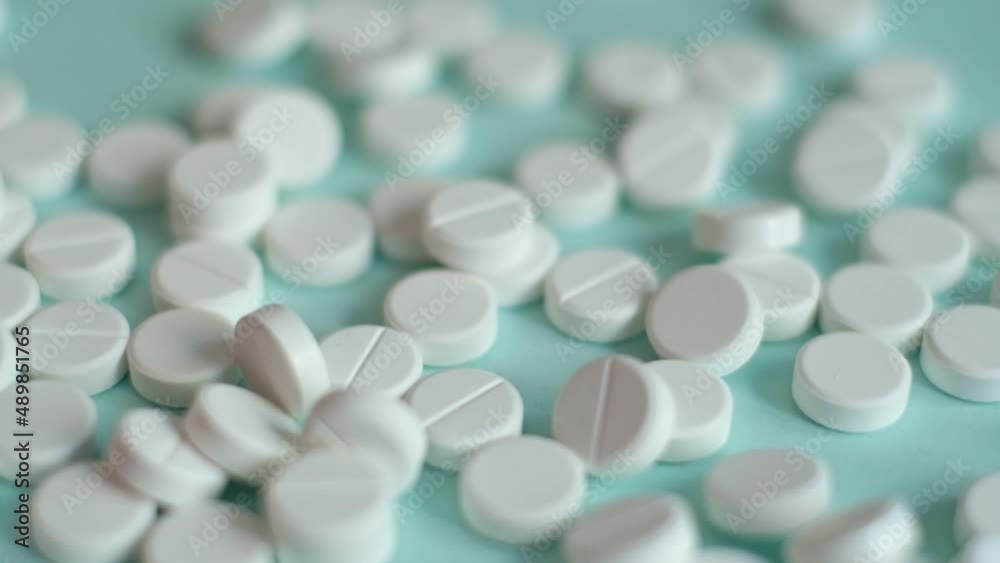 white pills on blue background in slow motion. medical footage, healthy lifestyle, vitamins, drugs white pills on blue background in slow motion. medical footage, healthy lifestyle, vitamins, drugs