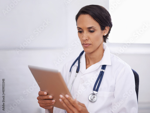 Looking for a better way. Shot of a young doctor using a digital tablet.