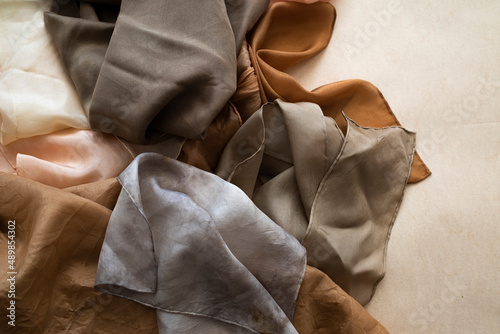 hand dyed clothes in warm natural tones hanging on a bright background - text space -
slow fashion concept 