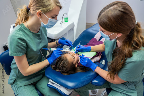qualified dentists check children's teeth with new professional equipment.