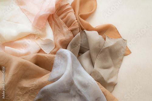 hand dyed clothes in warm natural tones hanging on a bright background - text space -
slow fashion concept  photo