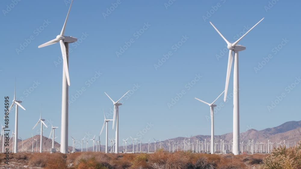 Windmills turbine rotating, wind farm power plant, alternative green renewable energy generators, industrial field in California desert USA. Electricity generation on windfarm. Palm Springs, Coachella Windmills turbine rotating, wind farm power plant, alternative green renewable energy generators, industrial field in California desert USA. Electricity generation on windfarm. Palm Springs, Coachella
