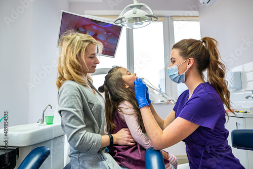 Little girl with her mom on visit their pediatric dentist