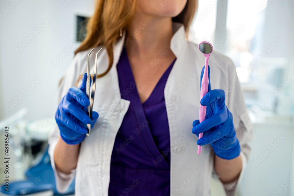 Young pretty female dentist stomatology in uniform and gloves at workplace cabinet Young pretty female dentist stomatology in uniform and gloves at workplace cabinet