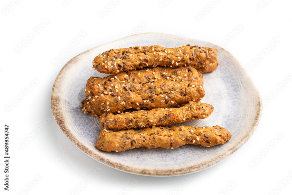 Crumble cookies with seasme and almonds on ceramic plate isolated on white background. side view, close up. Crumble cookies with seasme and almonds on ceramic plate isolated on white background. side view, close up.