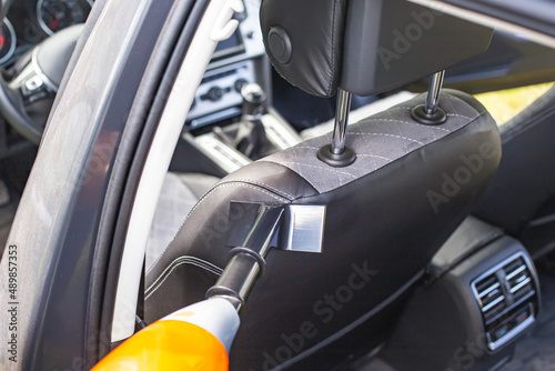 Cleaning a modern car interior with a vacuum cleaner from dirt and dust, background. Equipment