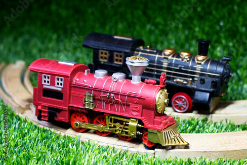 Toy train and rails on the grass in the garden