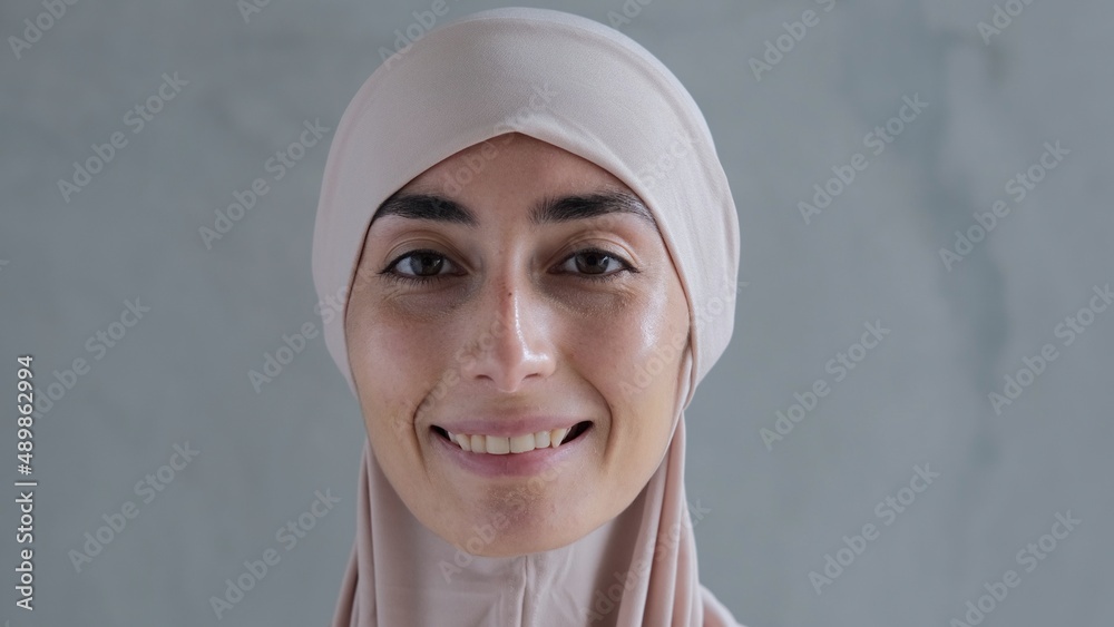 Cheerful cute Muslim young woman in hijab dress smiling and looking at the camera, pure happiness and joy Cheerful cute Muslim young woman in hijab dress smiling and looking at the camera, pure happiness and joy
