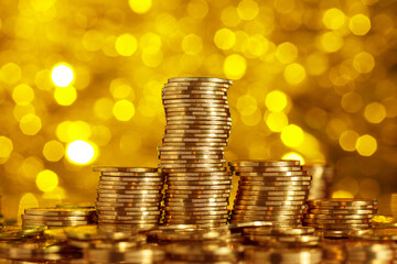 Golden coins stacks and heap with gold bokeh background