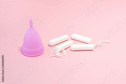 Menstrual cycle. Alternative means of hygiene and protection in critical days for women.Tampons or silicone menstrual cup on pink background. Сoncept : reuse, eco, safety. Selective focus. 