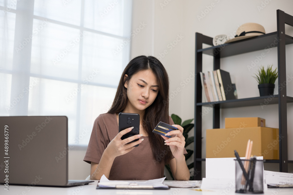 Stressed young asian woman holding smartphone and credit card in put the payment but Not enough money on credit card to pay Stressed young asian woman holding smartphone and credit card in put the payment but Not enough money on credit card to pay